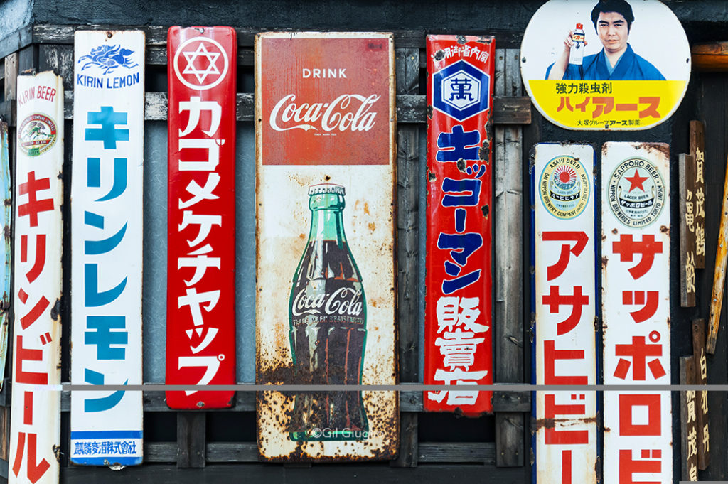 Plan rapproché sur anciennes publicités japonaise avec au milieu celle de coca Cola