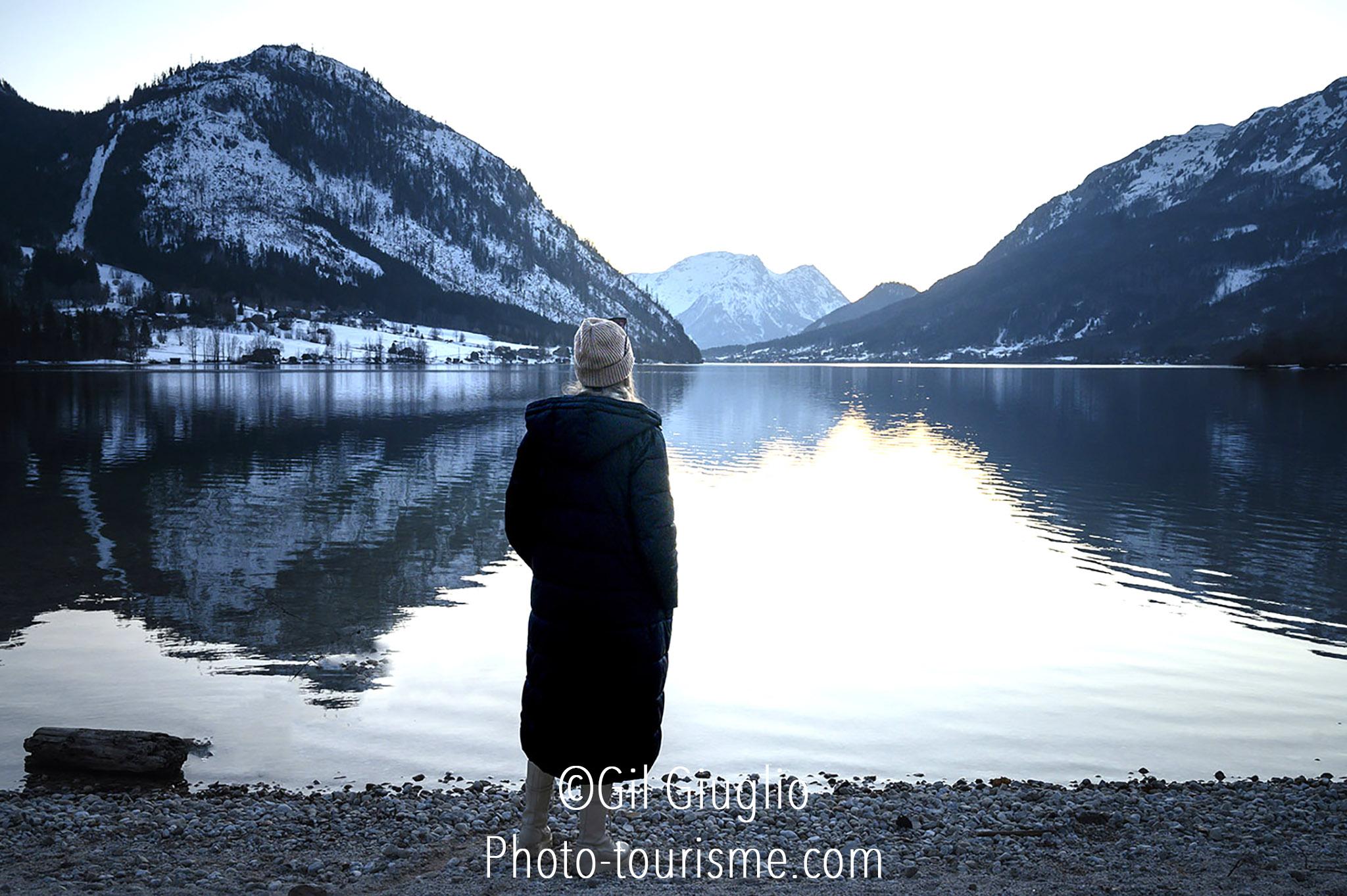 Jeune femme regarde un lac de montagne