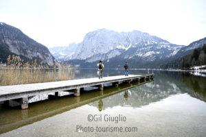 personnages sur passerelle d'un lac de montagne