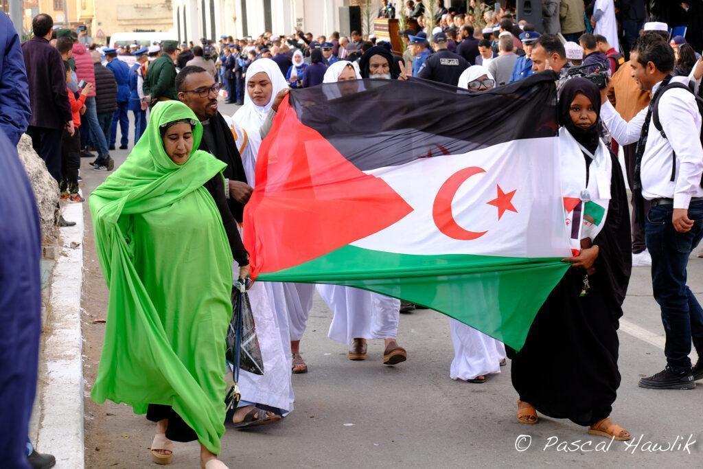 Femmes dans la rue tenant un drapeau algérien