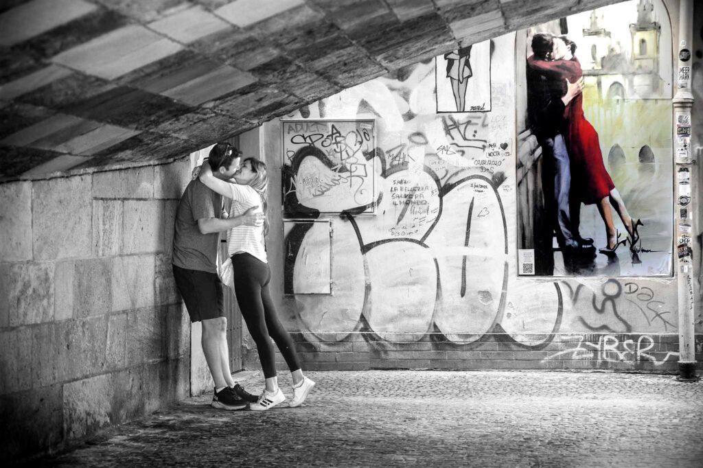 Un couple s'embrasse sous un pont pour faire mimétisme avec peinture mural sous celui-ci