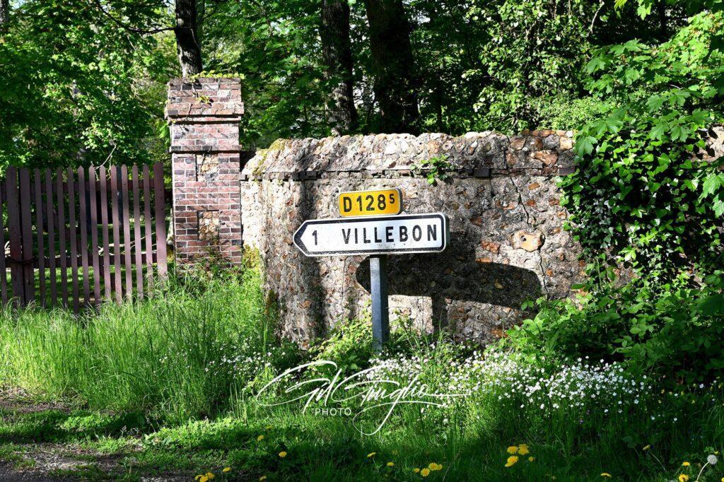 Panneau routier, végétation et vieilles pierres